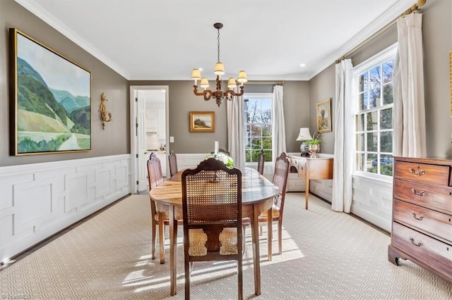 carpeted dining area with a notable chandelier and ornamental molding