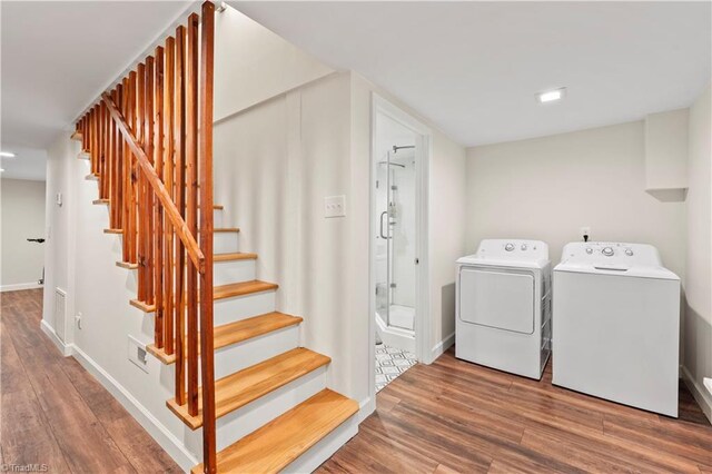 laundry room with hardwood / wood-style floors and washer and clothes dryer