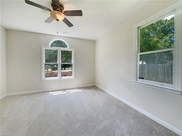 carpeted spare room featuring ceiling fan