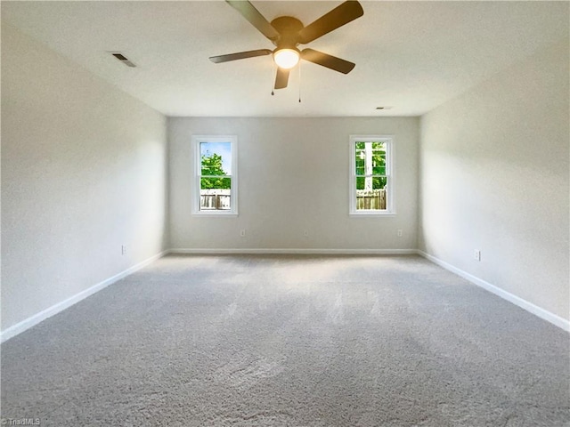 carpeted spare room with ceiling fan