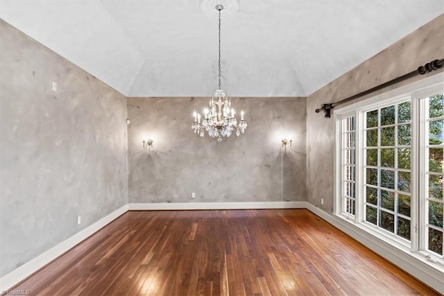 unfurnished dining area featuring an inviting chandelier, hardwood / wood-style floors, and vaulted ceiling