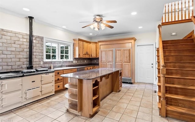 kitchen featuring dark stone counters, tasteful backsplash, crown molding, and a kitchen island