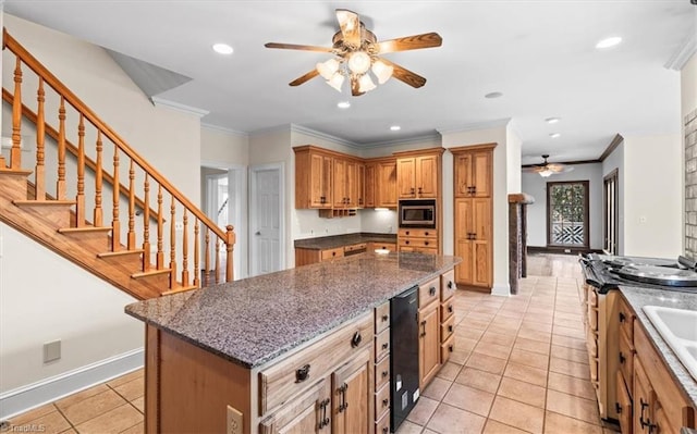 kitchen with light tile patterned floors, crown molding, a kitchen island, and stainless steel microwave