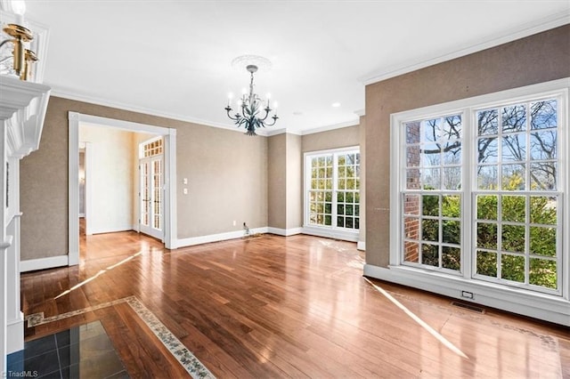 unfurnished dining area featuring wood-type flooring, crown molding, and a notable chandelier