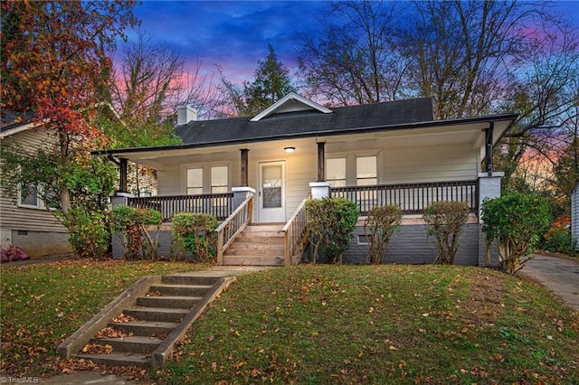 bungalow-style home featuring a porch and a lawn