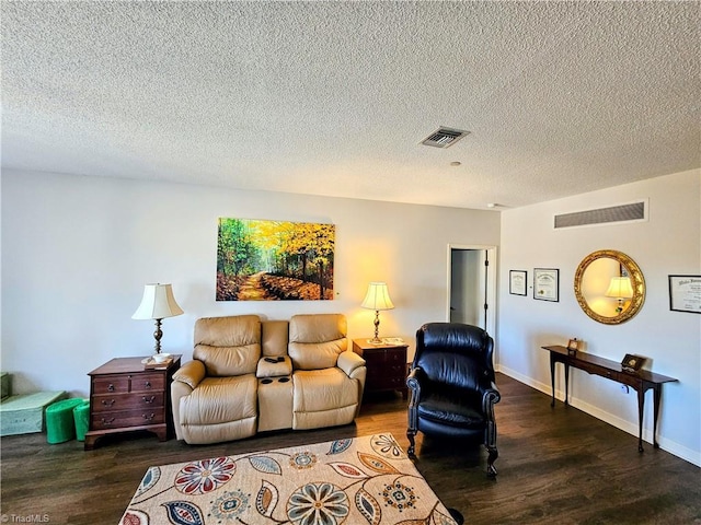 living area with wood finished floors, visible vents, and baseboards