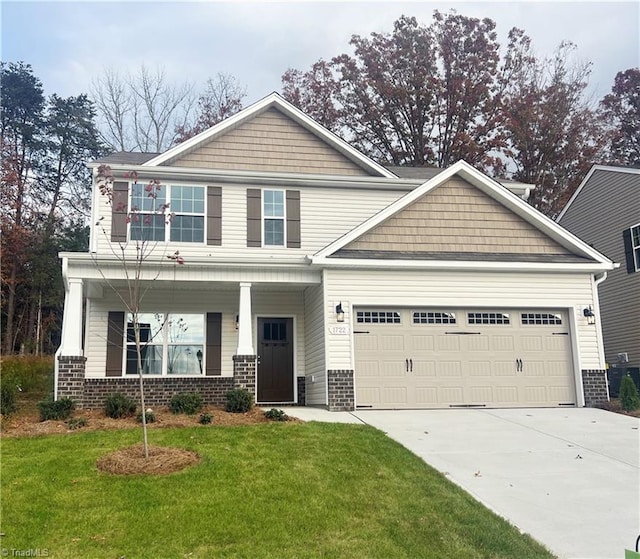 craftsman house featuring concrete driveway, a front lawn, an attached garage, and brick siding