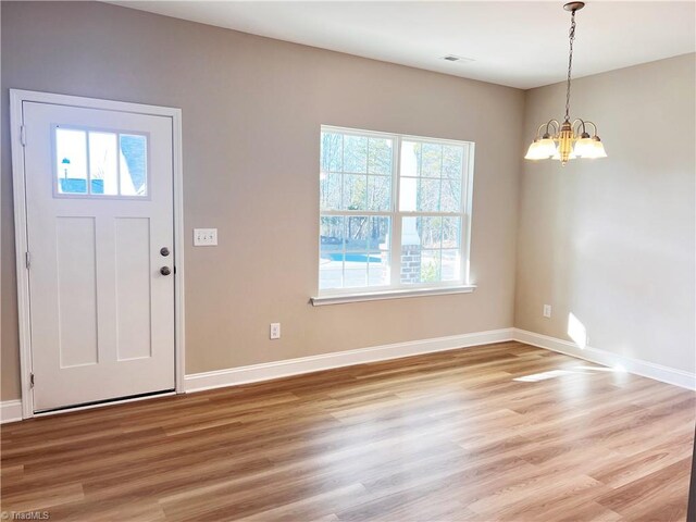 kitchen with a kitchen island, pendant lighting, light hardwood / wood-style floors, and stainless steel appliances