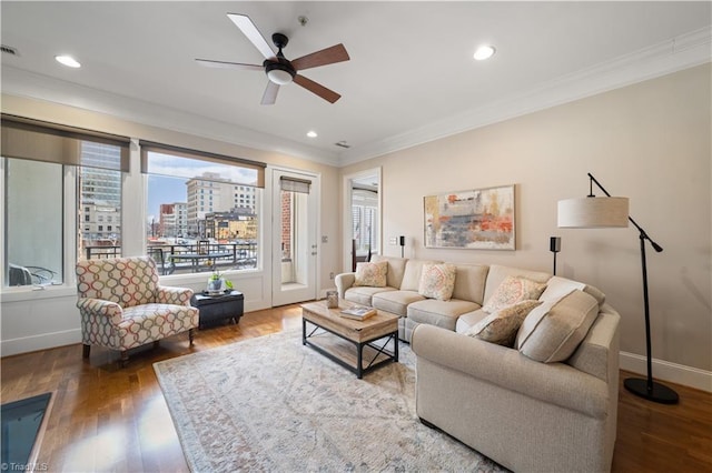 living room with wood finished floors, a healthy amount of sunlight, baseboards, and ornamental molding