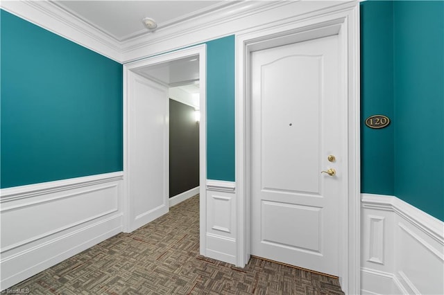 interior space with wainscoting and crown molding