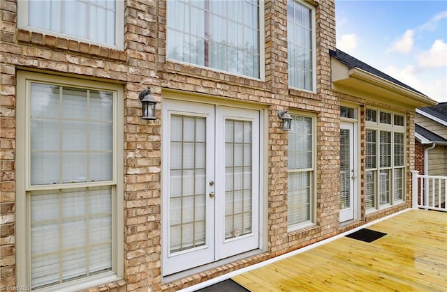 view of exterior entry with a deck and french doors