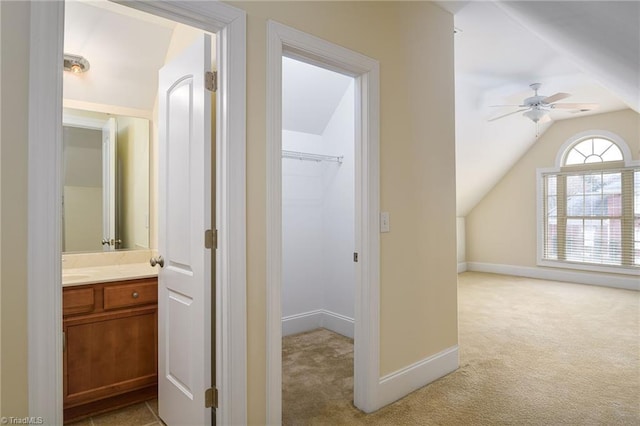 corridor with light carpet and vaulted ceiling