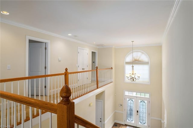 interior space with french doors, ornamental molding, and a chandelier