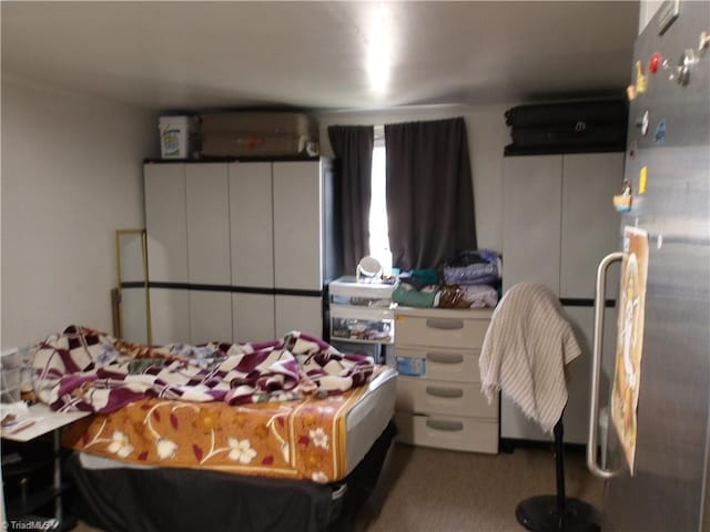 bedroom with carpet flooring and freestanding refrigerator