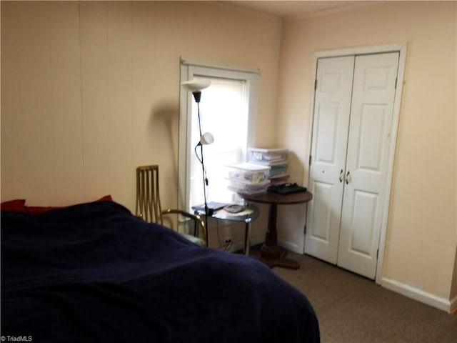 carpeted bedroom with a closet and baseboards