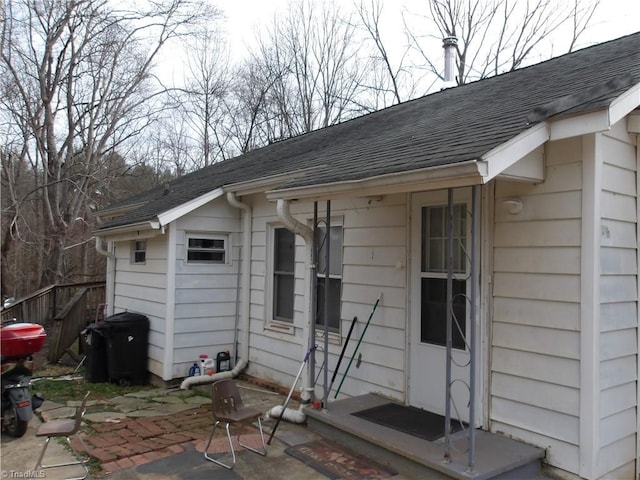 exterior space with a patio area, a shingled roof, and fence