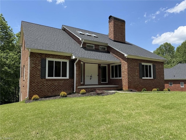 view of front of house featuring a chimney, brick siding, a front lawn, and a shingled roof