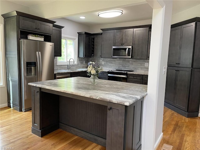 kitchen featuring stainless steel appliances, backsplash, light wood-style floors, and recessed lighting