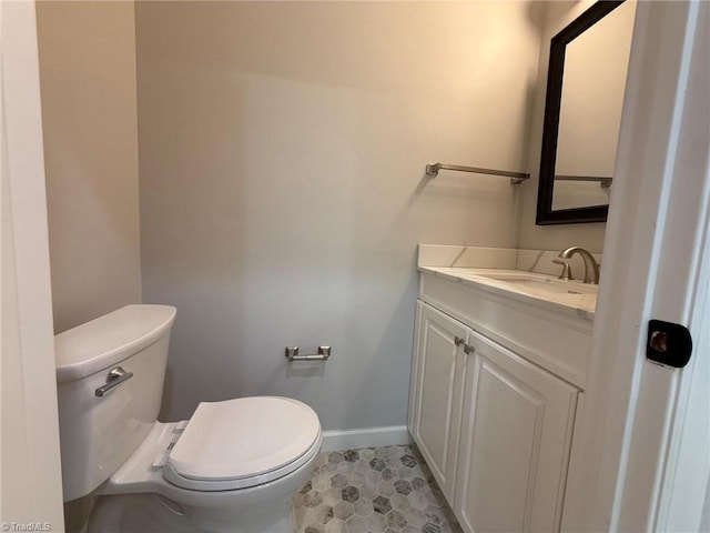 bathroom with baseboards, toilet, vanity, and tile patterned floors