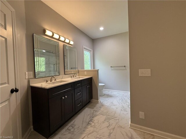 bathroom featuring marble look tile flooring, toilet, double vanity, baseboards, and recessed lighting