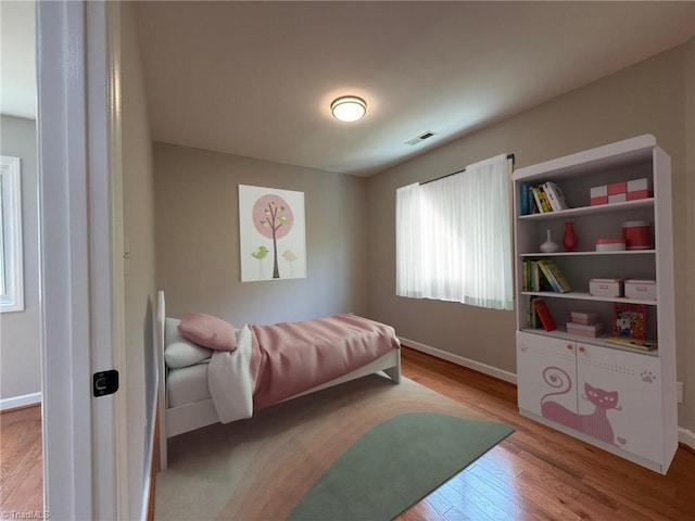 bedroom featuring wood finished floors and baseboards