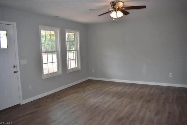 spare room with dark hardwood / wood-style flooring and ceiling fan