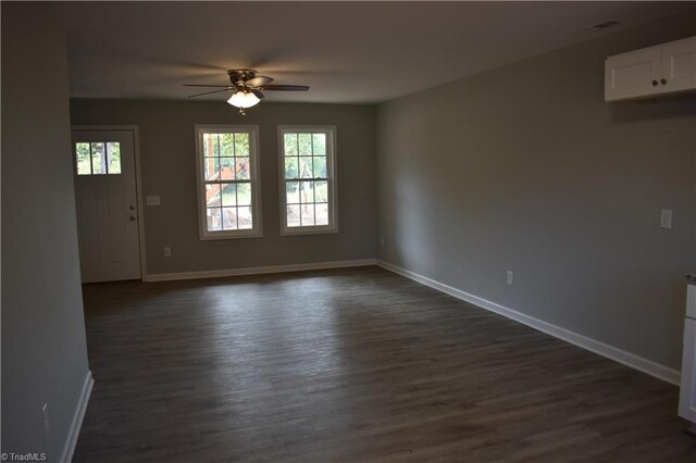 empty room featuring ceiling fan and dark hardwood / wood-style flooring