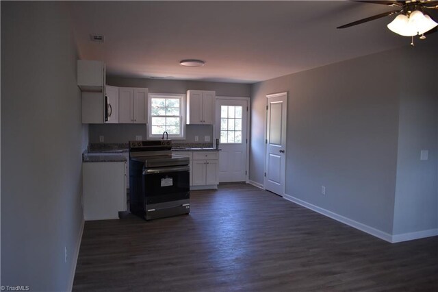 kitchen with dark wood-type flooring, stainless steel electric range oven, ceiling fan, and white cabinets