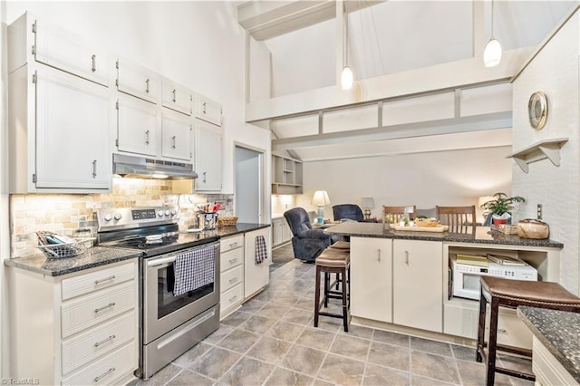 kitchen featuring electric range, dark stone counters, decorative light fixtures, a breakfast bar area, and white cabinets