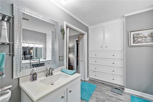 bathroom with crown molding, hardwood / wood-style floors, and vanity