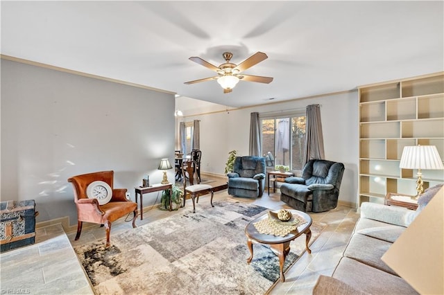 living room with ceiling fan and crown molding