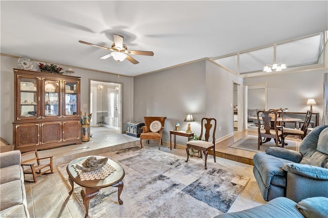 tiled living room with ceiling fan with notable chandelier and crown molding