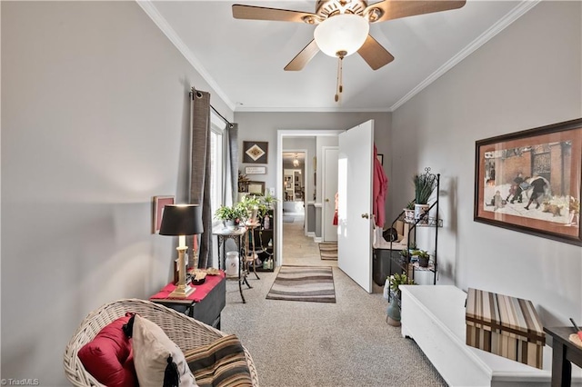 living area with ceiling fan, carpet, and ornamental molding