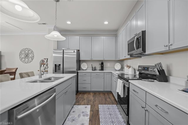 kitchen featuring pendant lighting, sink, gray cabinetry, dark hardwood / wood-style flooring, and stainless steel appliances