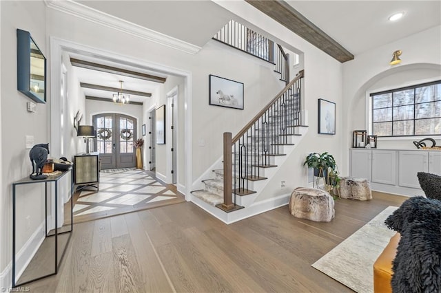 entryway featuring baseboards, stairway, wood finished floors, beamed ceiling, and french doors