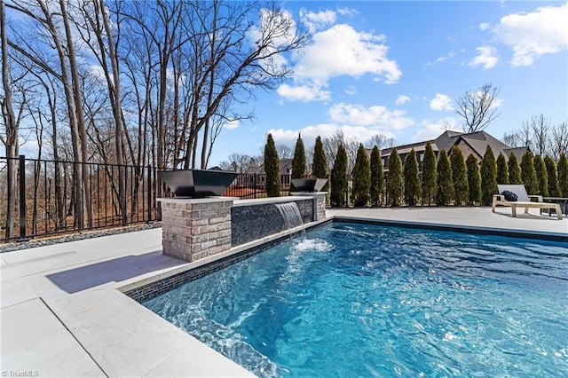 outdoor pool with a patio area and fence