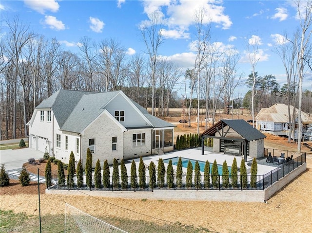 view of front of property featuring a fenced in pool, a patio area, a fenced backyard, and a gazebo