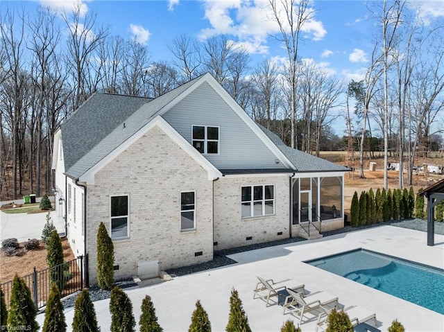 rear view of house with a patio, a sunroom, crawl space, fence, and brick siding