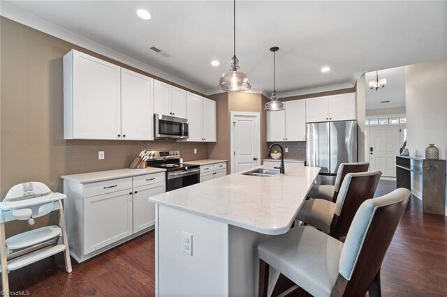 1423 Blooming Mountain Way, Kernersville, NC 27284 - kitchen featuring visible vents, a breakfast bar, white cabinetry, a sink, and stainless steel appliances