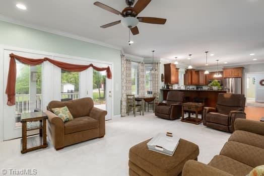 living room featuring ornamental molding and ceiling fan