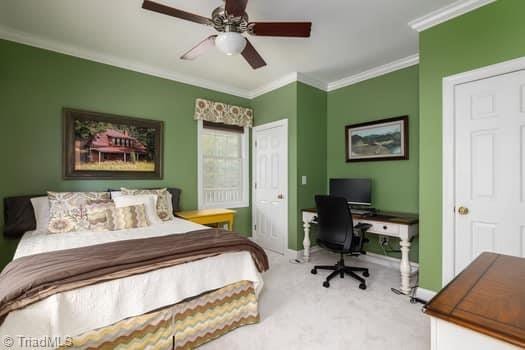 bedroom with carpet floors, ceiling fan, and crown molding