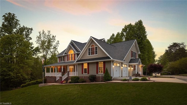 craftsman-style home featuring a garage, a porch, and a yard