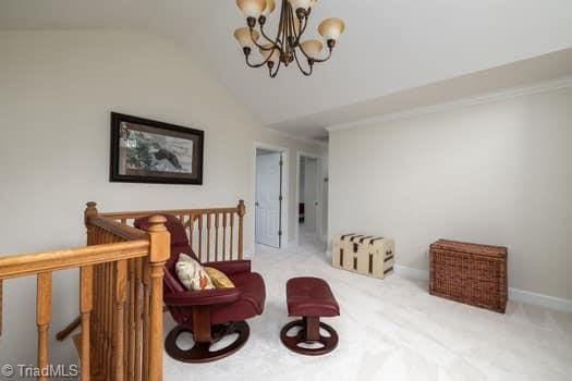 living area with vaulted ceiling, light colored carpet, and a notable chandelier