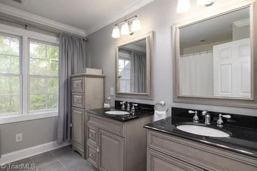 bathroom with crown molding, vanity, tile patterned floors, and plenty of natural light