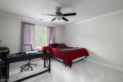 carpeted bedroom featuring ceiling fan and crown molding