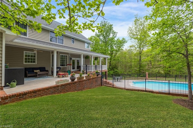 back of property featuring a yard, french doors, a patio area, a fenced in pool, and an outdoor living space