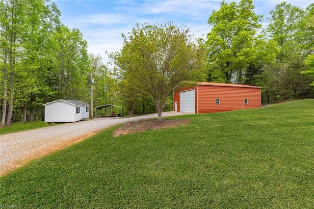 view of yard with a garage, a carport, and an outdoor structure