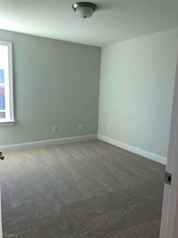 carpeted spare room with baseboards