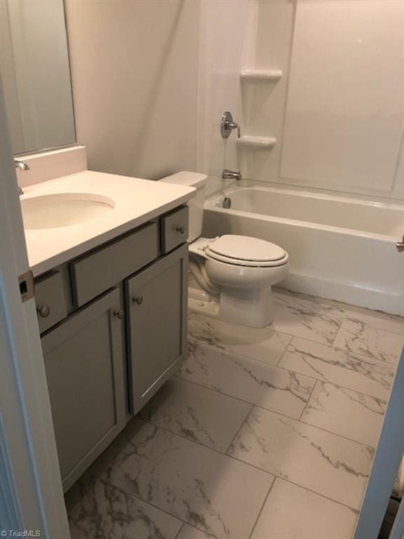 bathroom featuring toilet, marble finish floor, shower / tub combination, and vanity