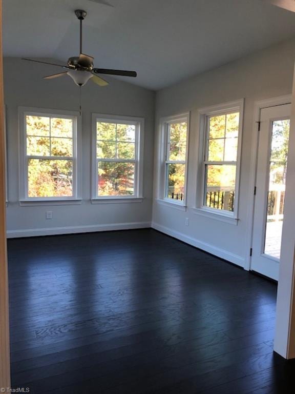spare room with dark wood-type flooring, a ceiling fan, lofted ceiling, and plenty of natural light